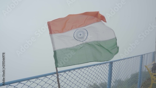 Foto National flag waving in strong wind on foggy mountain peak with national mountai