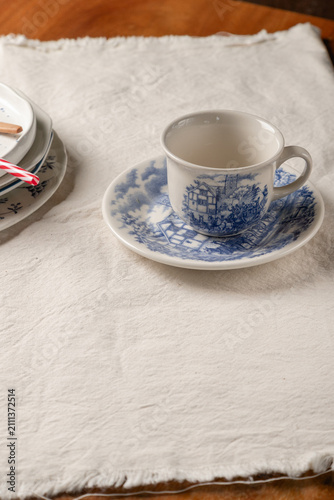 Obraz na plátně Blue and White Teacup and Saucer on Linen with Negative Space