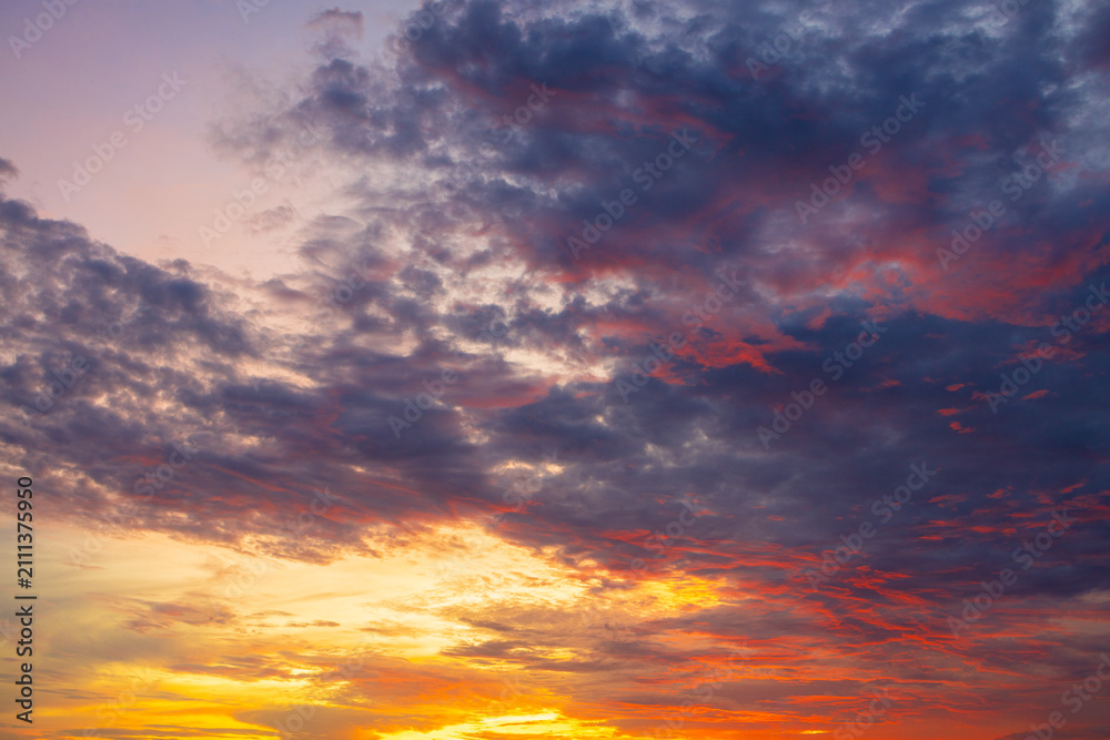 Fototapeta premium Stunning Vibrant Sunset Sky with Dramatic Colorful Clouds,A breathtaking and dramatic sunset sky filled with vibrant golden, orange, purple, and dark blue clouds, creating a peaceful and inspiring.