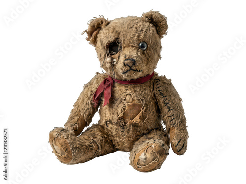 Worn teddy bear with patches isolated on transparent background. Nostalgia and childhood concept.