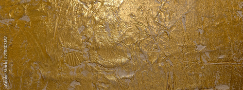 Close-up view of a golden textured Venetian plaster surface showcasing intric...