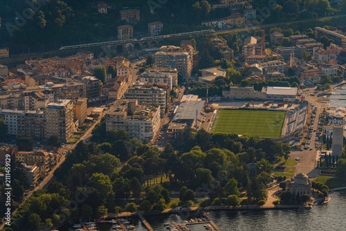 Foto Aerial view of Como city showcasing residential buildings, green parks, and a fo