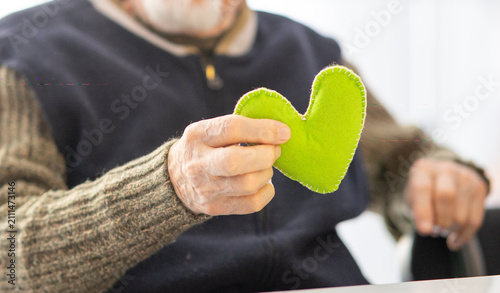 Bild auf Leinwand Person holding handmade green felt heart toy