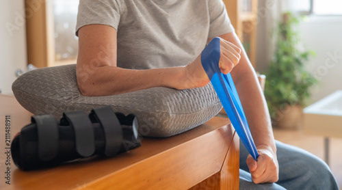 Obraz na płótnie Person exercising wrist with a resistance band for physiotherapy and rehabilitat