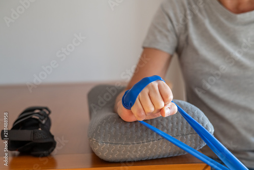 Fotografie Person performing wrist flexion exercises with a resistance band, strengthening