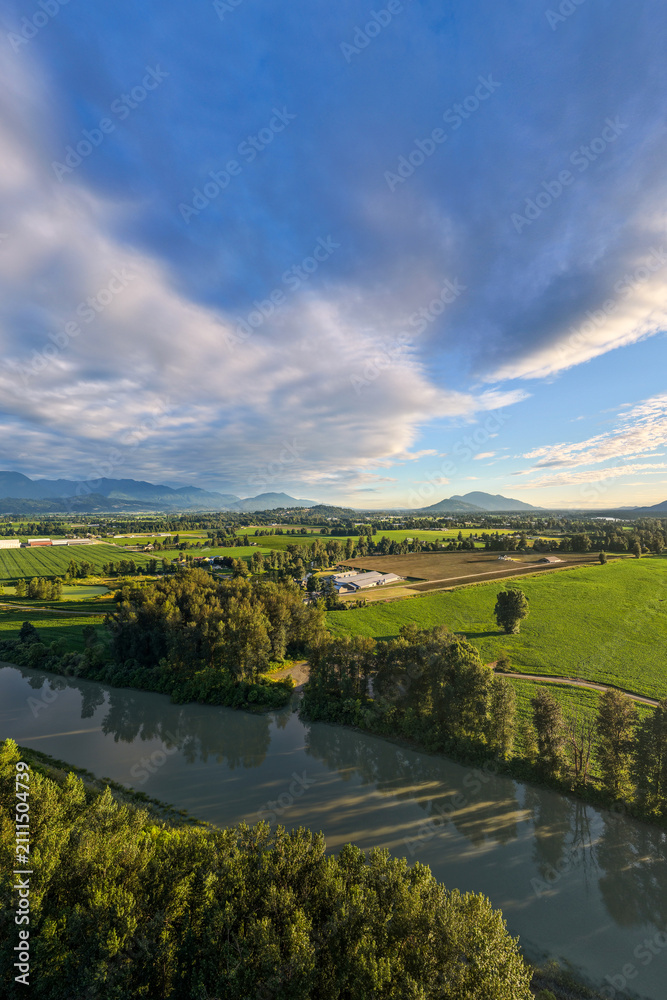 Fototapeta premium Aerial View Of Fraser Valley Farmland And River Near Chilliwack British Columbia Canada With Dramatic Sky