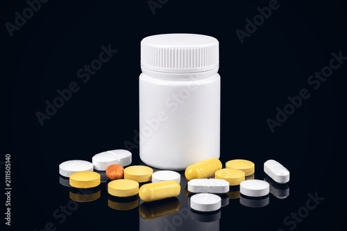 Fotografie Assorted Pharmaceutical Tablets and Capsules with White Medicine Bottle Isolated