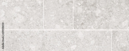 Light grey stone tiles surface for architectural flooring design featuring square slab patterns with natural granite mineral finish and clean white grout line spacing.