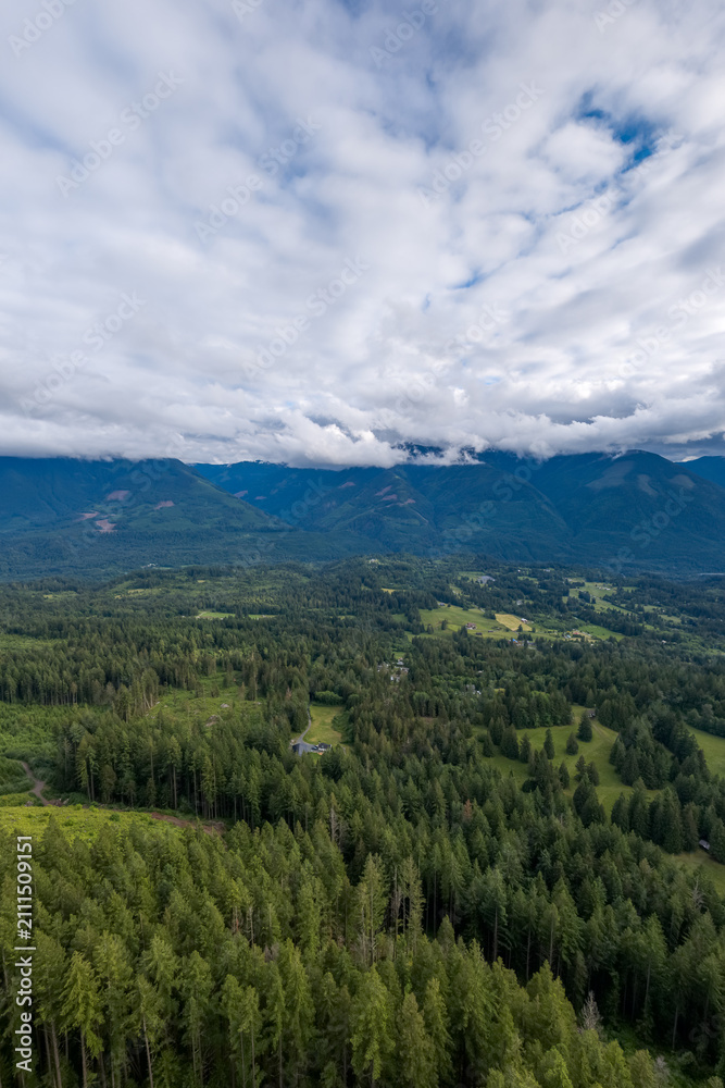 Obraz premium Aerial View of Fraser Valley Forests and Mountains Under Dramatic Cloudscape Near Chilliwack, British Columbia