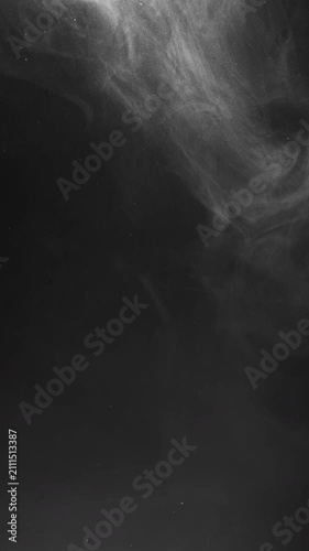 White smoke drifts and swirls across a dark background, forming shifting, ethereal patterns as it moves downward.