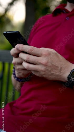 Close-up of hands typing on a phone. Close up shot of Caucasian human hands using mobile phone while on street. Fingers typing and tapping on smartphone. Hands texting and scrolling outdoors. Technolo