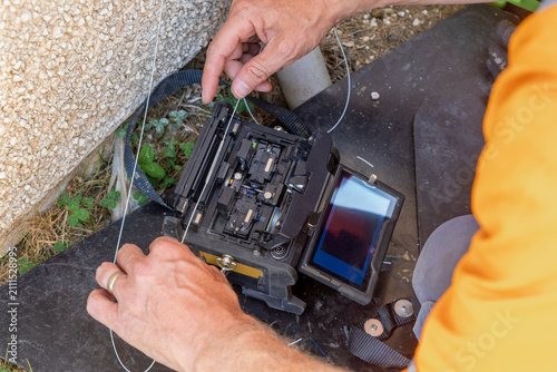 Canvastavla Telecoms engineer feeding spliced fibre with protective heat shrink sleeve into