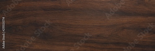 Dark walnut wood texture background, polished mahogany timber surface with natural grain patterns, elegant brown wooden board for interior design mockups and furniture product displays