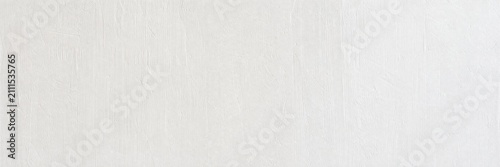White linen fabric texture background with subtle vertical weave. Minimalist off-white cotton textile surface. Clean light gray canvas material for interior design and fashion mockups.