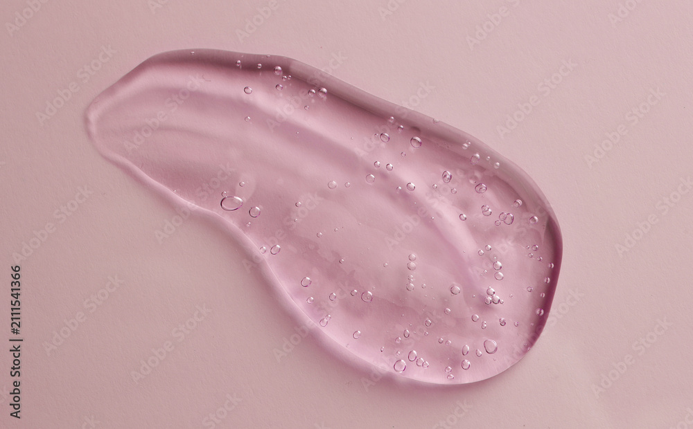 Fototapeta premium Smear of pink cosmetic gel on color background, top view