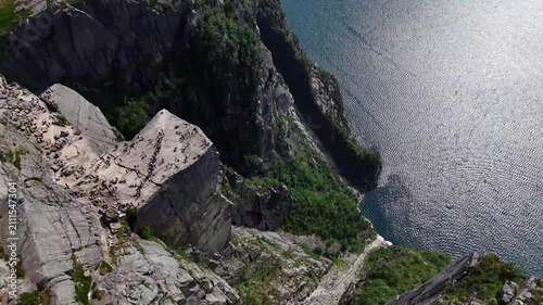 Drone perspective of Preikestolen cliff and rugged granite plateau overlooking the blue waters of Lysefjord in Norway.
