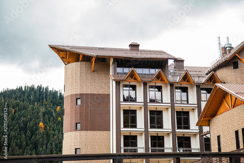 Horizontal view of alpine hotel buildings with balconies in Arkhyz mountain resort.