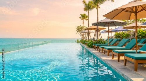 Luxury Infinity Pool Overlooking The Ocean At Sunset With Sun Loungers And Palm Trees