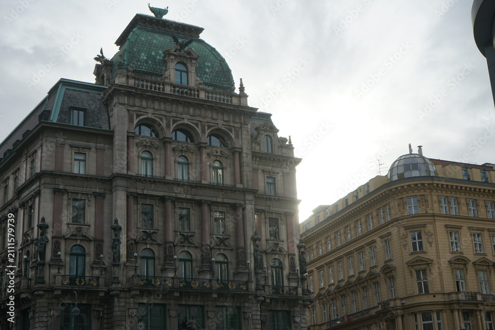 Obraz premium Ornate historic buildings with green copper dome against bright sky