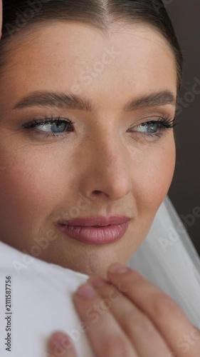 Beautiful bride looking away, leaning on the groom's shoulder, close-up.