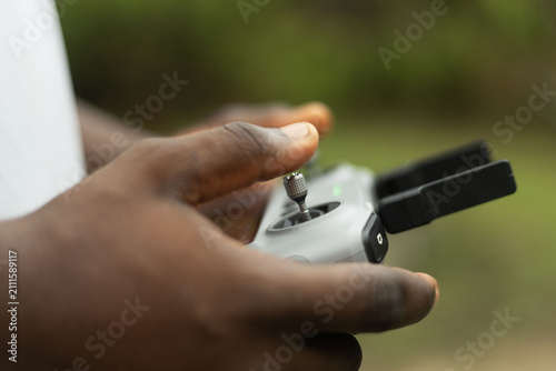 Hands operating the remote of a drone device
