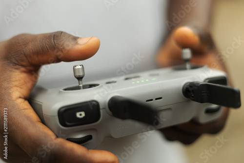 Hands operating the remote of a drone device