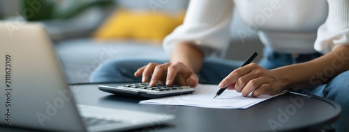 Accounting woman using a calculator for personal finance and budget planning home