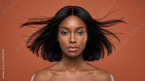 Stunning young Black woman with straight bob hair and bare shoulders, premium beauty portrait for glowing skincare and luxury cosmetics