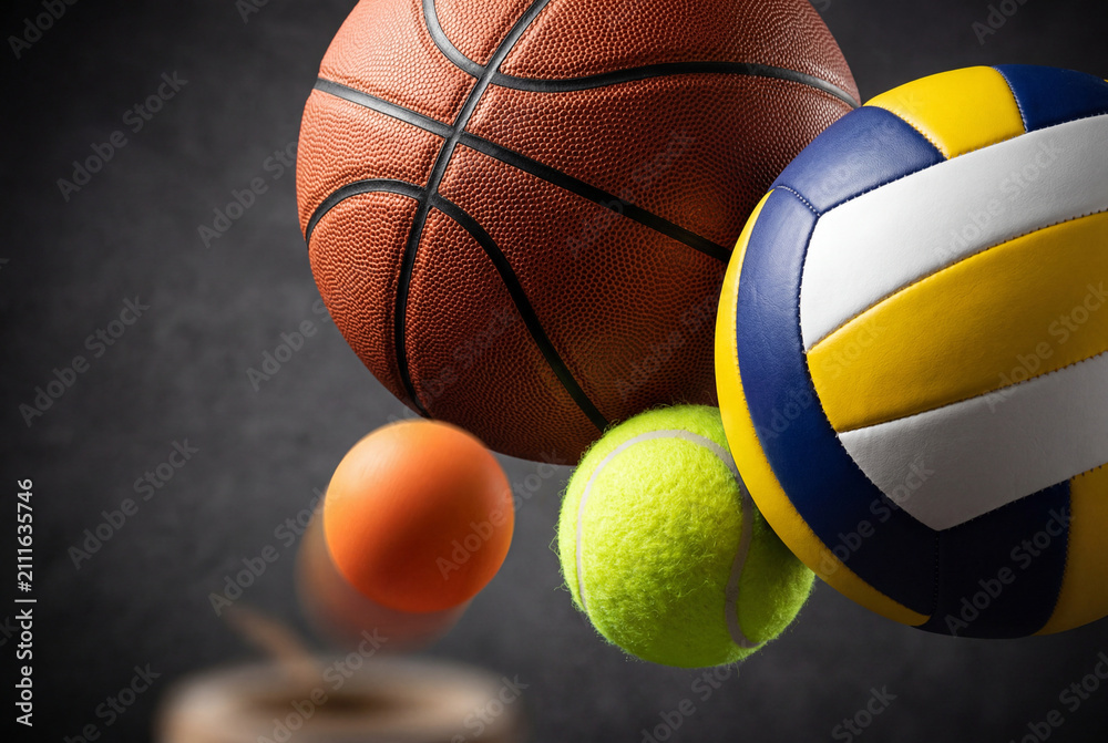 Fototapeta premium Dynamic studio arrangement of assorted sports balls including basketball volleyball and tennis ball