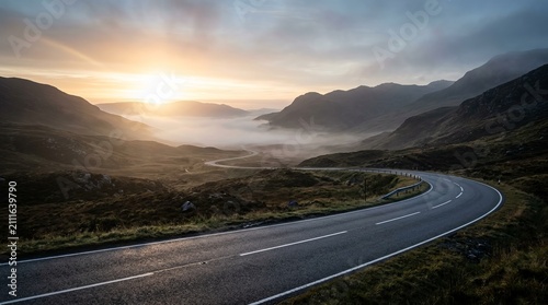 Scenic winding road through misty mountains at sunrise, dramatic landscape, adventure travel