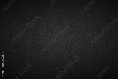 Fotografie Black paper sheet texture with light vignette background
