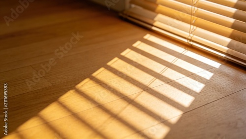 Sun rays filtering through blinds onto natural wood floor su