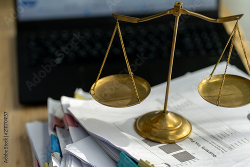 Obraz na płótnie Golden scales sit atop a stack of papers