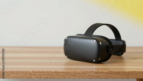 Black VR headset on a wooden table against a light background.