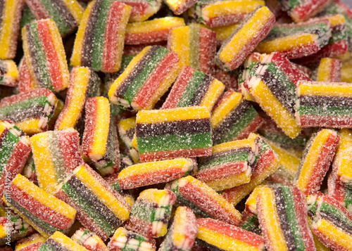 Close up of small pieces of licorice in multiple colors. Yellow, black, green and red. Sweet treat.