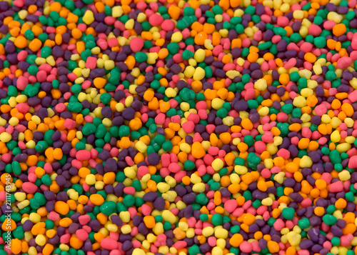 Close up of hundreds of tiny brightly colored candy. Sweet treat background.