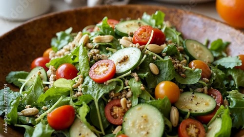 Vibrant, fresh garden salad with mixed greens, cherry tomatoes, and cucumber in a wooden bowl.