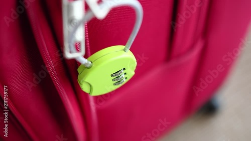 Lock on a red suitcase in a busy airport setting