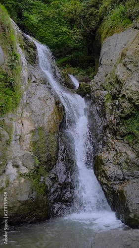 Vertical video: Andrew the Apostle waterfall in the mountain - river or stream of water is flowing and falling down - slow motion. Nature, landscape and environment concept