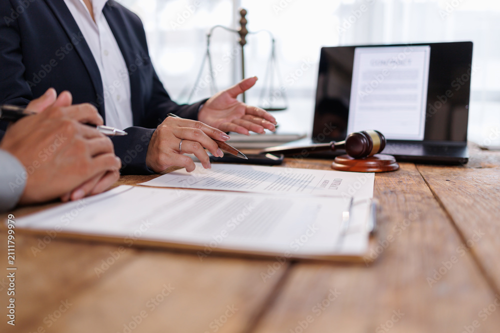 Obraz premium Legal professional discussing contract terms and offering advice to client in office, focusing on law, justice, and agreement, with gavel and scales symbolizing authority and arbitration