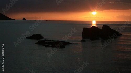 奄美大島の夏の夕日 黄金色に染まる海とリーフの海岸風景