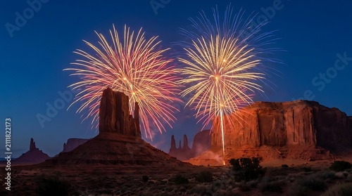 Fireworks display over desert sandstone buttes at night.