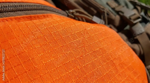 Bright orange fabric texture detail with outdoor gear elements