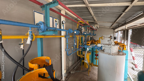 Konstfotografi Industrial LPG gas cylinder station with manifold pipeline system, pressure gauges, control valves, and storage tanks for energy distribution