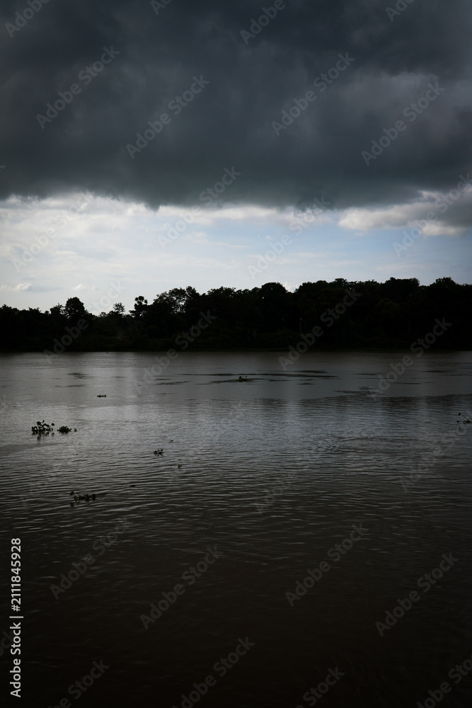 Fototapeta premium Tropical river after tropical rain storm with dramatic clouds
