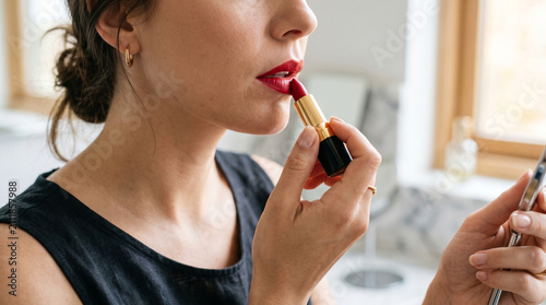 woman applying red lipstick