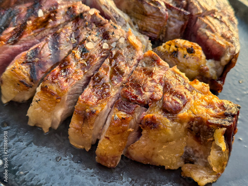 Beefsteak Florentine style is an Italian steak dish made of young steer or heifer that is one of the most famous dishes in Tuscan cuisine. Tasty rib-eye steak on a plate. Close-up view on meat