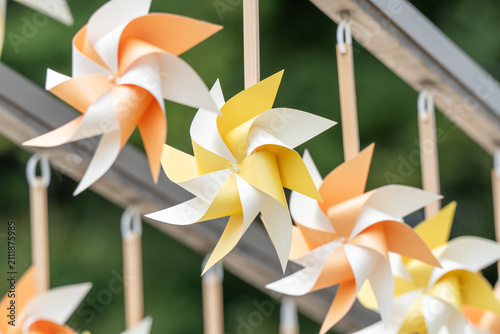 Colorful Paper Pinwheels Hanging in a Row Outdoors
