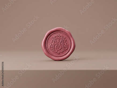 Pink wax seal with decorative monogram letter w on a simple solid surface