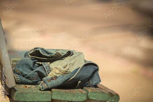 Obraz na płótnie Discarded denim jacket on a weathered park bench